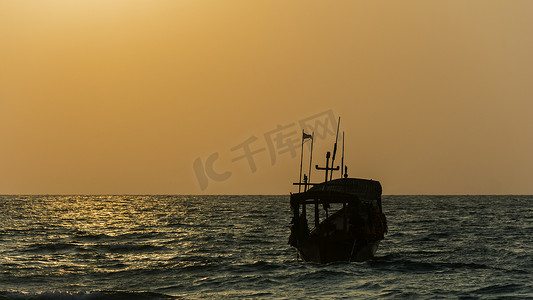 在海洋的日出和小船的剪影