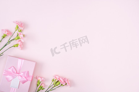 三八背景摄影照片_粉红色康乃馨和粉红色背景礼盒的母亲节设计理念
