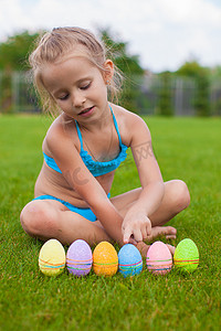 小美女在绿草上发现复活节彩蛋