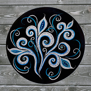 装饰陶瓷板，手绘点图案与灰色木制背景上的丙烯酸涂料。