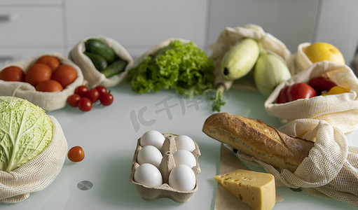 桌上可重复使用的生态棉袋中的蔬菜、水果、鸡蛋。