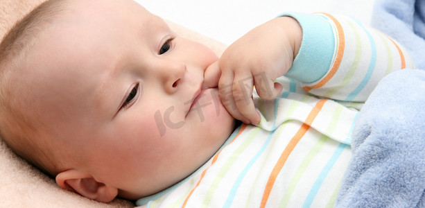 婴儿躺在床上手指含在嘴里