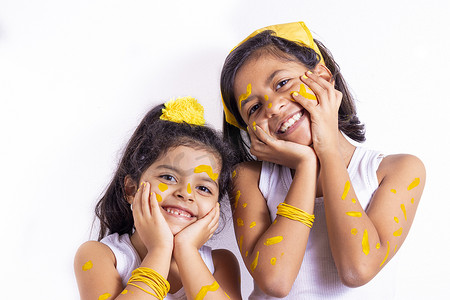 两个小女孩，脸上涂着彩绘来庆祝黄色的日子