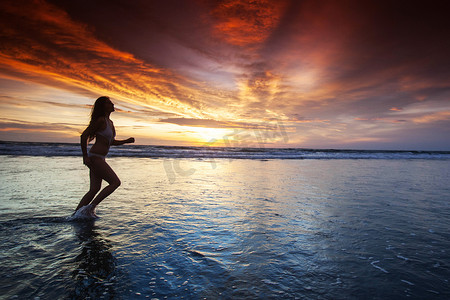 海边夕阳天空摄影照片_海边奔跑的女人
