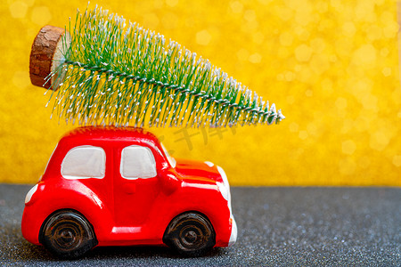 红色玩具车载着一棵圣诞树过节。