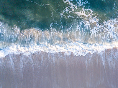 无人机拍摄的海浪拍打海滩的照片。