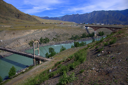旅程卡通摄影照片_绿松石色的山河河床上的新旧桥。
