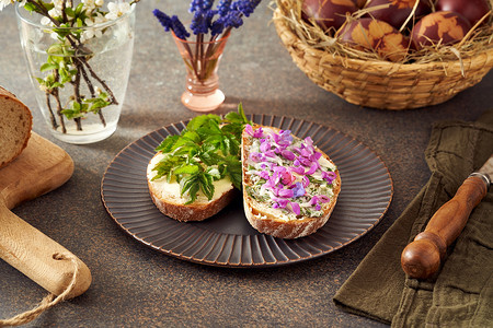 可食用的摄影照片_酵母面包配黄油和可食用的春季野生植物——痛风草叶、紫色死荨麻和肺草