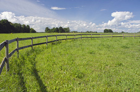 绿色农田摄影照片_带木栅栏的乡村景观农田
