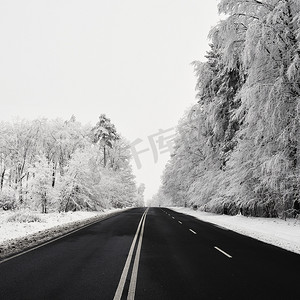 有积雪的风景的空的路。