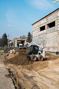 在与土壤一起使用的建筑工地的白色滑移转向装载机。