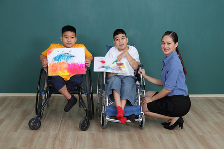 一群患有残疾和自闭症的年轻女孩正在用水画画来训练手和手指的肌肉。