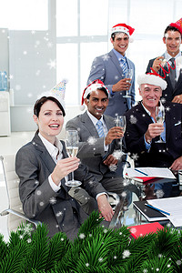 经理和他的团队戴着新奇的圣诞帽在聚会上敬酒