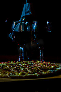 红酒和美味的比萨饼，薄皮上有培根、火腿、蘑菇和马苏里拉奶酪