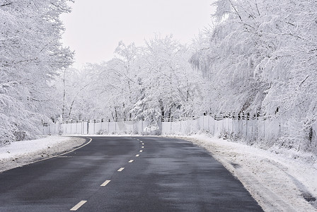 有积雪的风景的空的路。