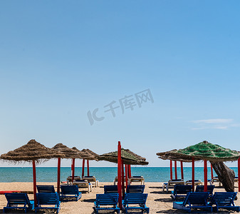 富埃特文图拉岛空荡荡的海滩上有两个吊床的孤独柳条太阳伞。