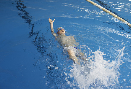 衣服泡在水里摄影照片_游泳池里的儿童游泳者