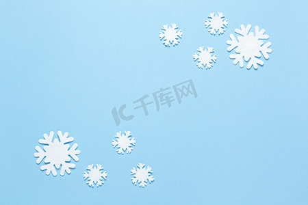 圣诞作文，一组小白毡雪花在柔和的蓝色背景上，复制空间。