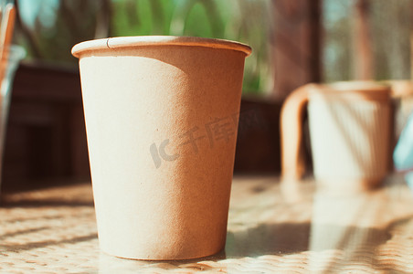 咖啡厅桌上的一次性纸咖啡杯，配有木制搅拌器。环保生活方式。零废物，拯救地球，地球日，无塑料，回收概念