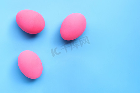 复活节彩蛋，蓝色背景上的粉红色彩蛋。