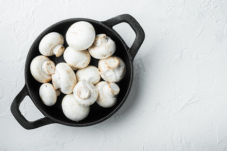 煎堆摄影照片_蘑菇香菇，铸铁煎锅，白石表面，顶视图平躺