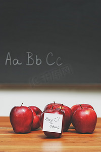 桌上有便条的苹果，背景是黑板