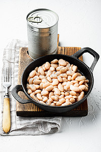 白罐装豆子，金属罐头，铸铁煎锅，白石表面