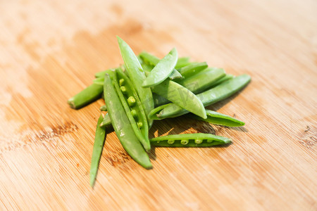 在砧板上切豌豆或荷兰豆