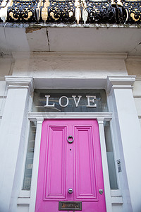 英国白色房屋粉色门上方的“爱”字