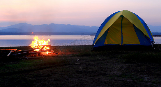 日落时的帐篷和篝火，在湖边