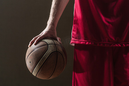 红色的篮球摄影照片_关闭篮球运动员举行的篮球