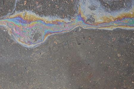沥青上的油渍、沥青路上的彩色汽油燃料斑点作为纹理或背景