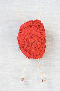 浅色背景中用于编织的大红色纱线、木针