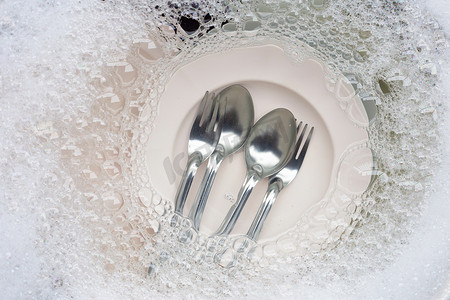 陶器摄影照片_洗碗，关闭浸泡在厨房水槽中的器具。