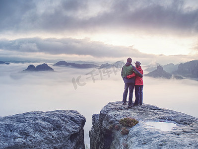 蜜月假期摄影照片_夫妇在攀登落基山顶后欣赏美景