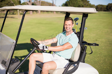 多人高尔夫摄影照片_驾驶高尔夫球车的愉快的高尔夫球手人