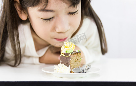 吃巧克力摄影照片_女孩盯着蛋糕