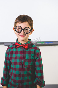 微笑的男孩站在教室白板上