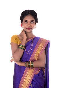 印度纱丽摄影照片_美丽的印度年轻女孩穿着白色背景的传统印度纱丽。