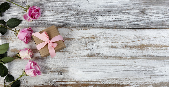 花真摄影照片_质朴木板左侧的真粉色玫瑰花和礼盒，供母亲节或情人节使用