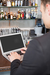 在餐厅使用笔记本电脑的商人
