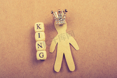国王加冕摄影照片_国王字样旁边的微型模型皇冠