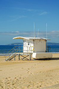 安全假期摄影照片_沙滩上的白色救援小屋，在海边安全放松，阳光明媚的一天