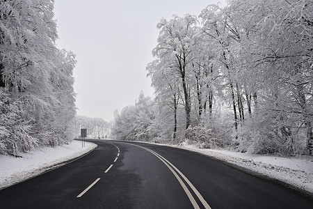 有积雪的风景的空的路。