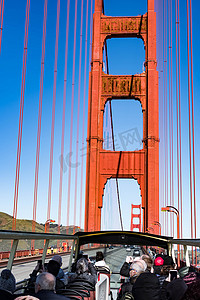 旅游巴士摄影照片_2020 年 3 月 31 日，美国加利福尼亚州旧金山，金门大桥和一些游客在旅游巴士上