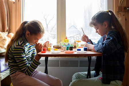 水粉装饰摄影照片_家里的孩子们在餐桌上为假期制作工艺品和礼物