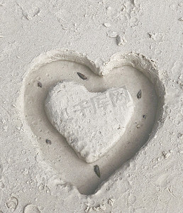 手绘海滩背景摄影照片_沙滩上手绘抽象心的顶角特写，感觉，爱情概念。