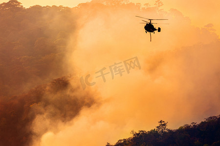 非洲森林摄影照片_消防直升机在森林火灾中洒水