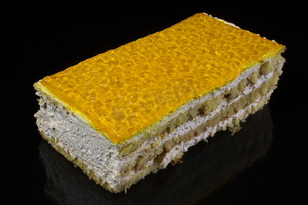 一块蛋糕，上面有一个大计划，上面覆盖着深色背景上用果冻制成的黄色釉料