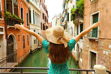 欧洲旅行度假有趣的夏日女人，双臂高举，帽子在意大利威尼斯快乐。